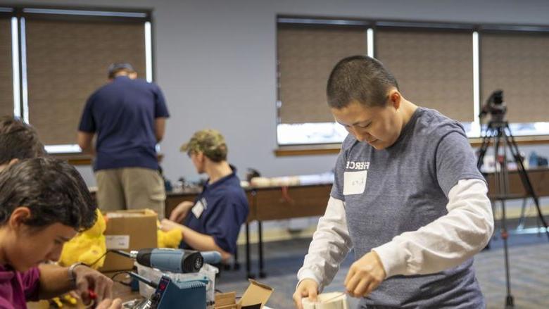 Berks student helps high school student with soldering toys.